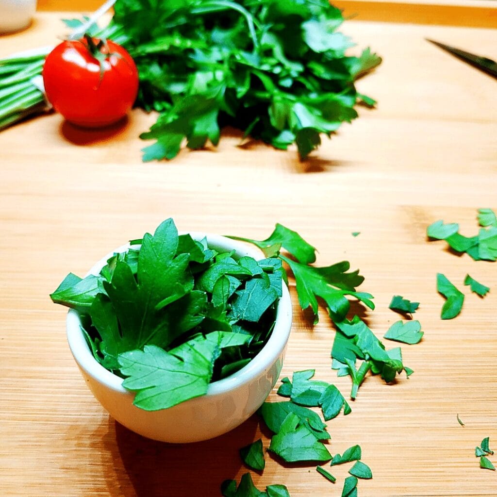 Always buy fresh parsley and use it as garnish or to add flavor to your meat soup. Pictured here is chopped parsley in a white bowl.
